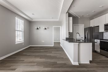 An open kitchen and living room with a large window and a black and white